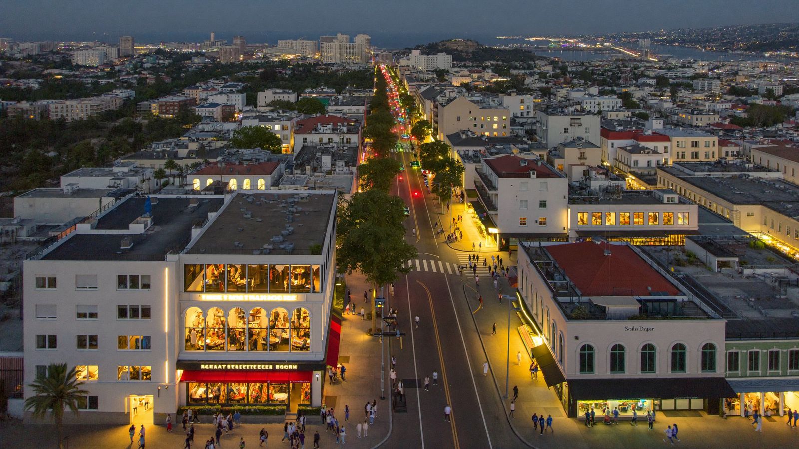 San Diego neighborhood dining district at dusk Aerial view of a San Diego dining neighborhood at dusk with restaurants lit along the main street