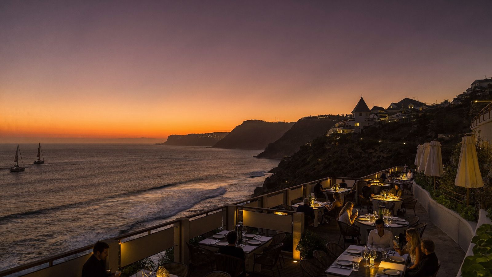 Sunset over the La Jolla coastline with cliffside dining terraces